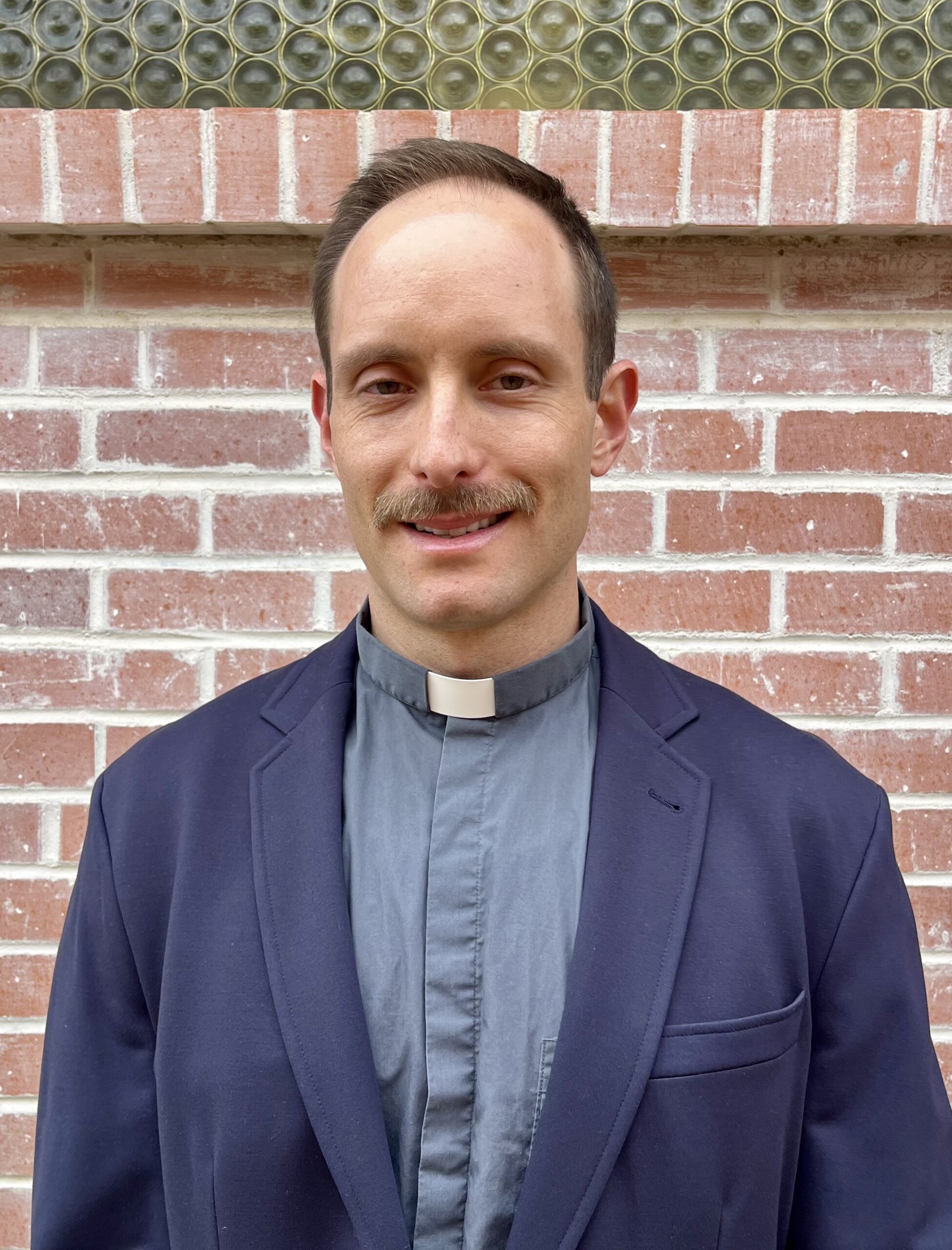 Anglican priest portrait at King of Grace Anglican Church in Tucson AZ wearing clerical collar and blazer