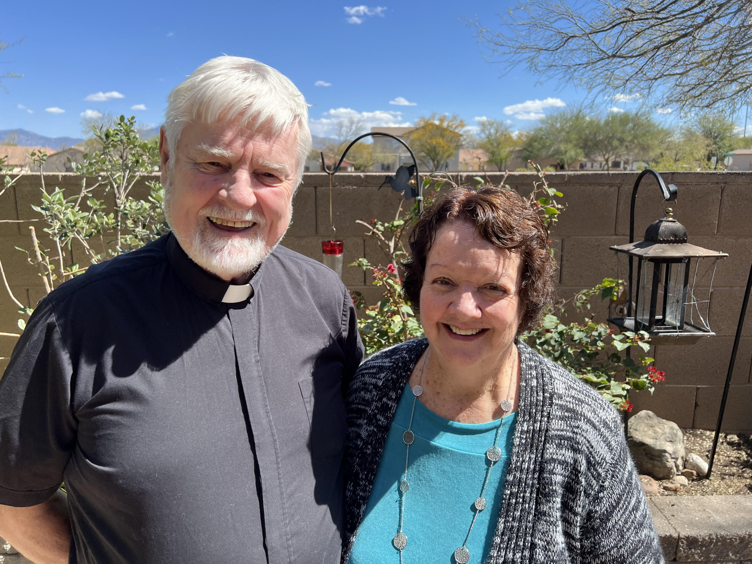 Smiling clergy couple standing outdoors from King of Grace Anglican Church in Tucson, Arizona